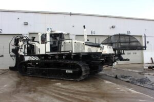 BRON utility tractor with a large cable reel attachment, stationed outside a warehouse.